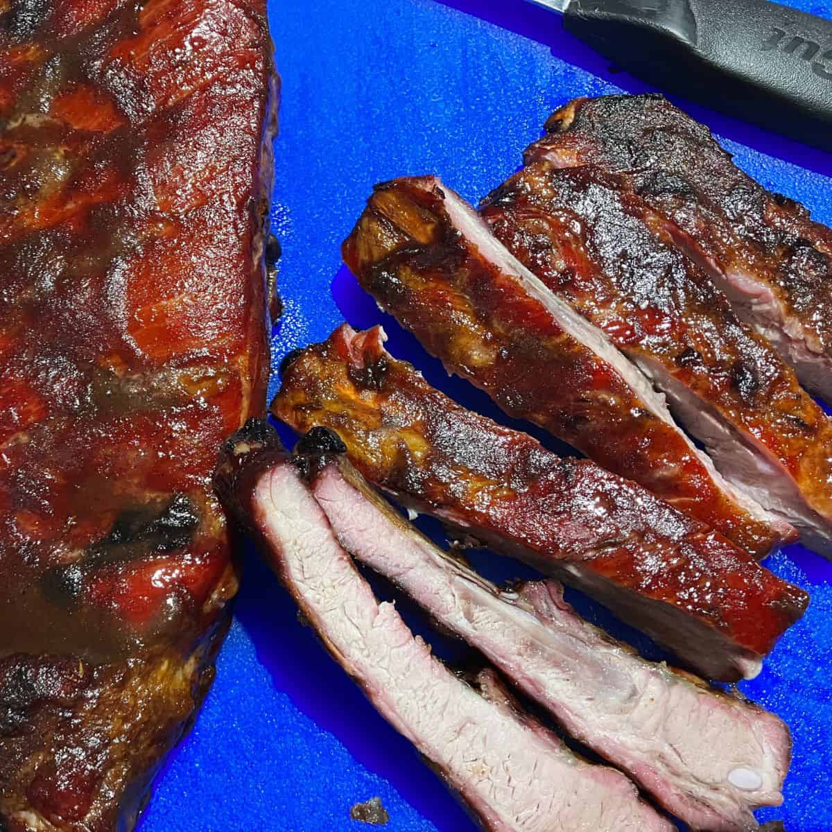 ribs ready to eat sitting on blue cutting board
