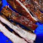 ribs cut and ready to eat sitting on blue cutting board