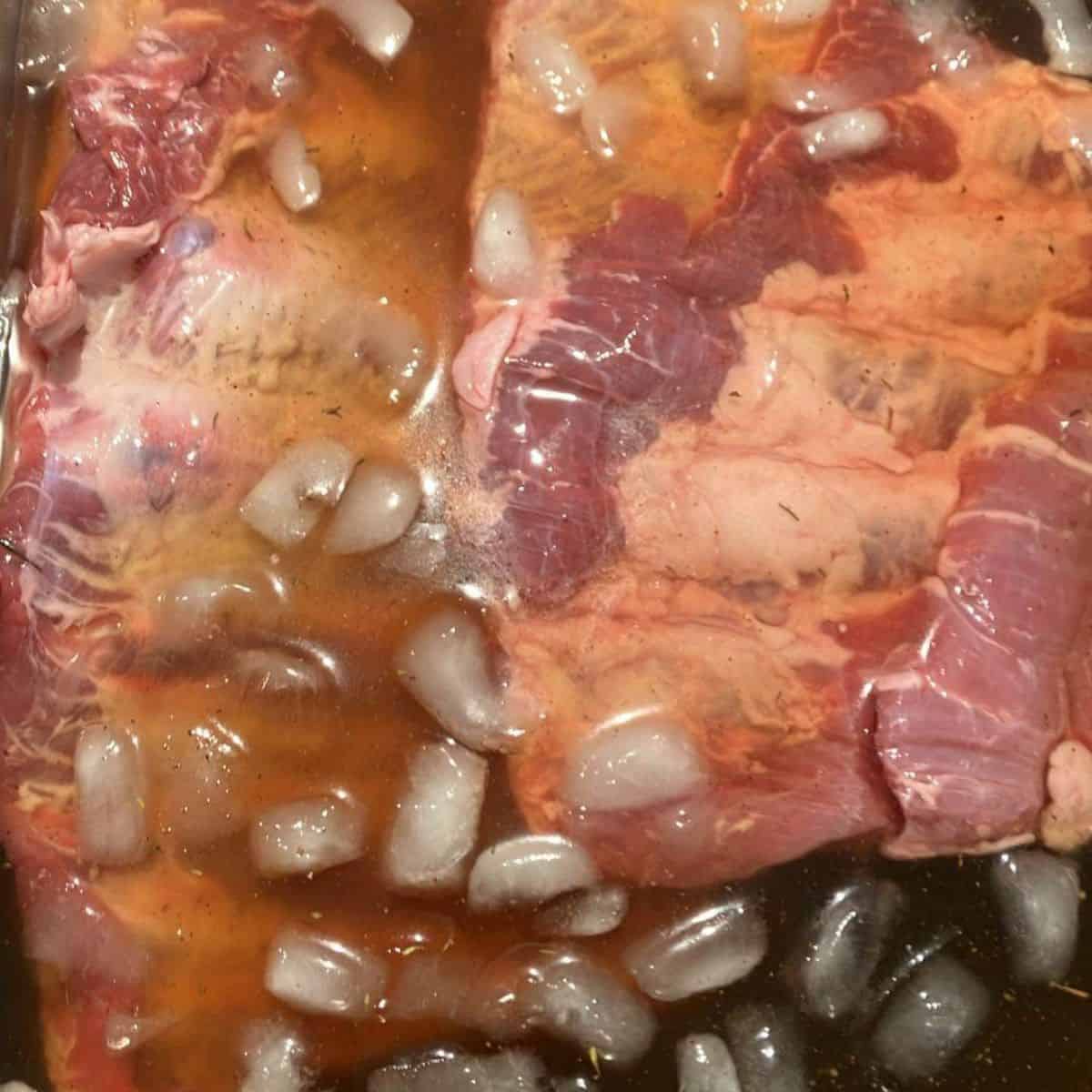 Pork ribs soaking in brine that's been cooled with ice water.