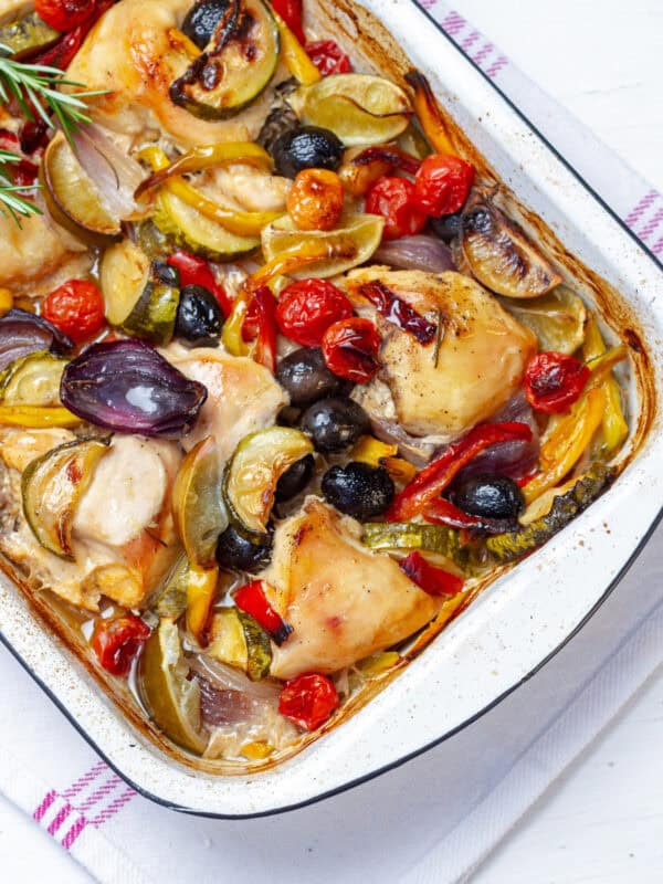 Simple yet delicious—Greek Lemon Chicken with olives and colorful vegetables in a baking dish.