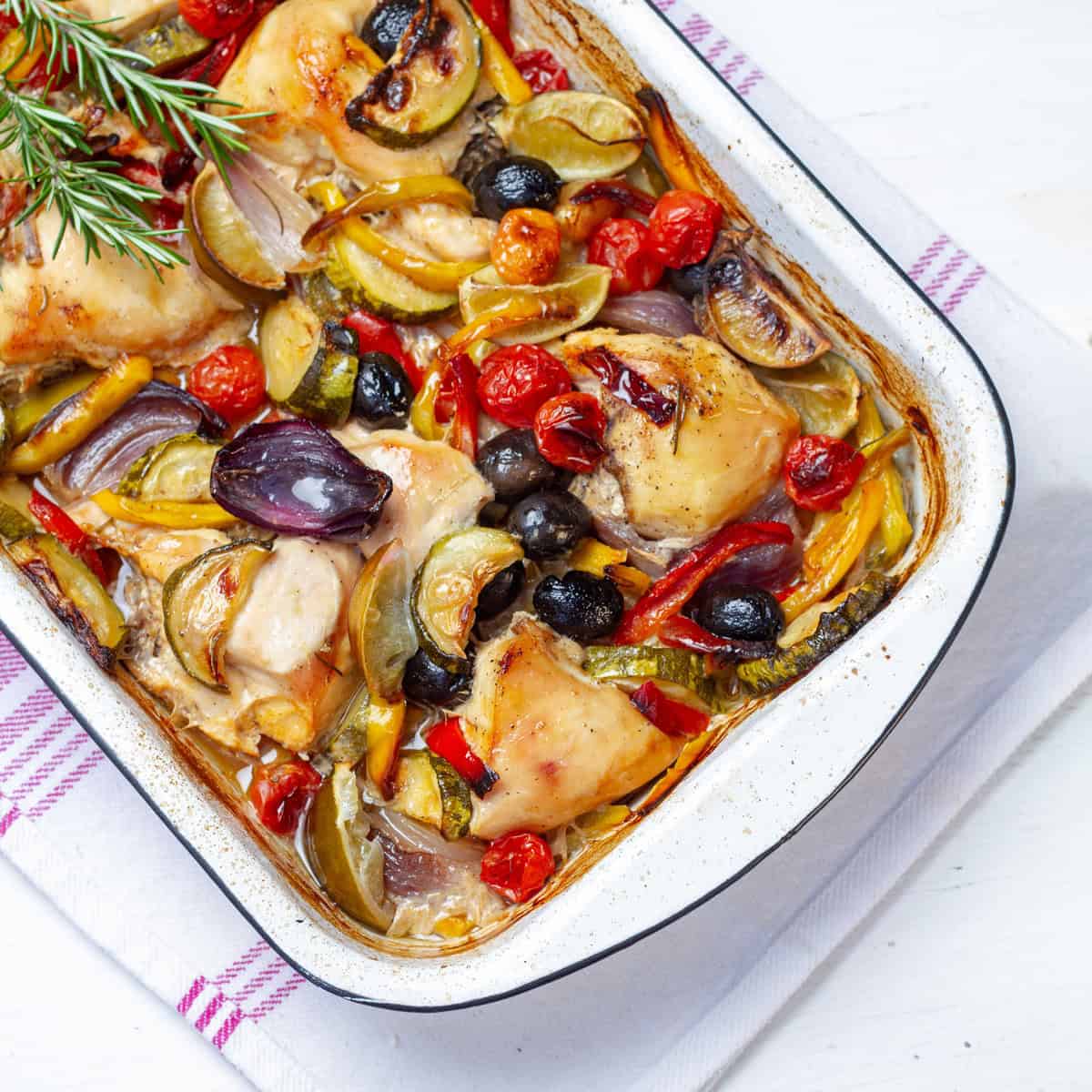 Simple yet delicious—Greek Lemon Chicken with olives and colorful vegetables in a baking dish.