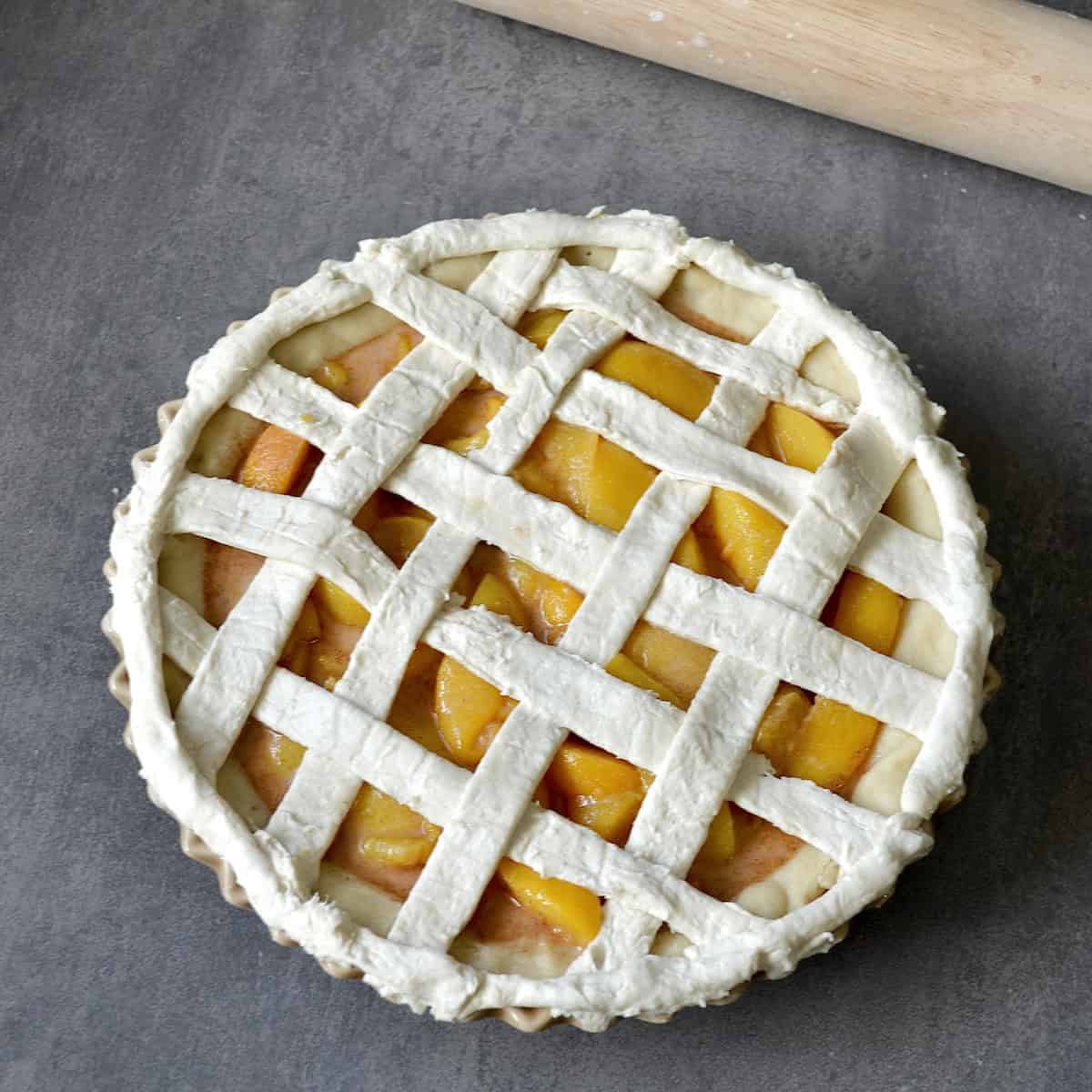Unbaked peach pie with a lattice crust