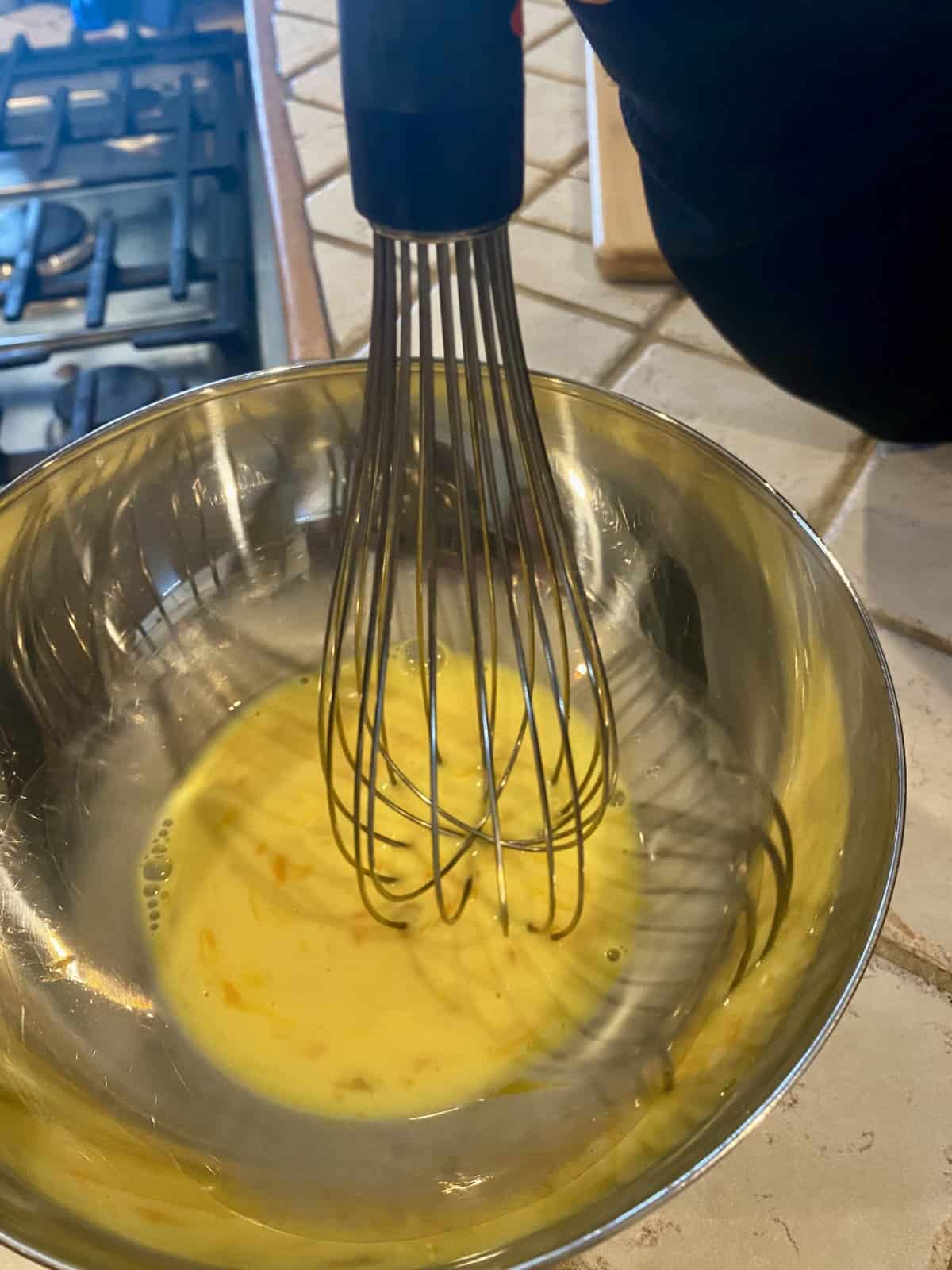 whisking eggs and milk in a bowl