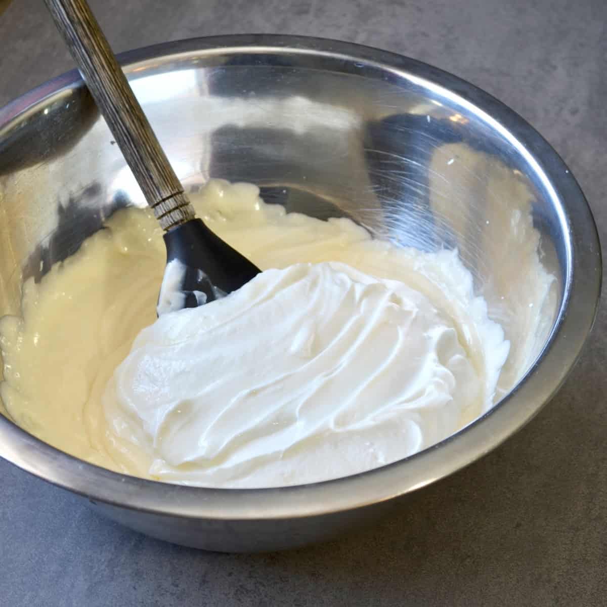Making cheesecake fluff in a large mixing bowl