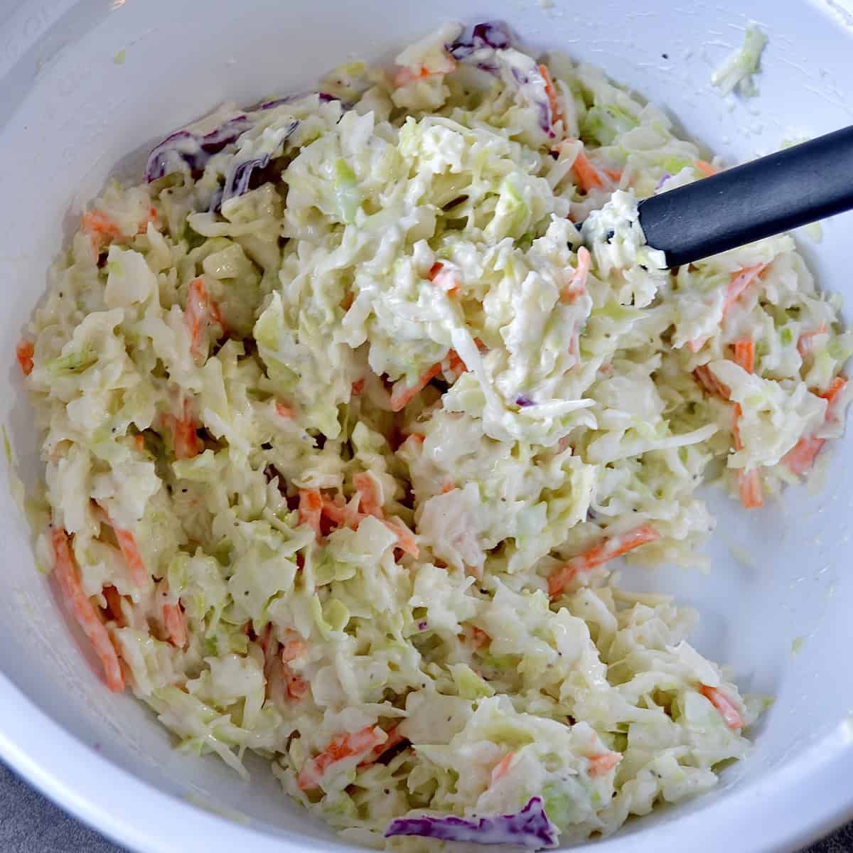 Mixing coleslaw dressing and cabbage