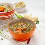 Brothy and satisfying egg roll soup in an orange bowl.