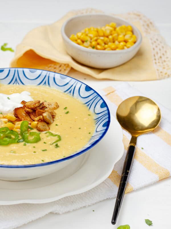 Mexican Creamy Corn Soup in a bowl with a spoon.