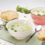 Creamy and delicious Broccoli Cream Soup in a bowl with a spoon and bread on the side.