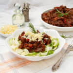 Instant Pot Beef Ragu served over zucchini noodles and topped with freshly grated cheese.