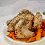 Juicy and succulent Slow Cooker Whole Chicken on a serving platter with carrots.