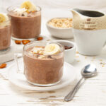Creamy and chocolate Choco Oats in a small glass with a banana slice on top.
