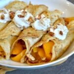 Crepes with peach filling and whipped cream
