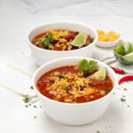 Delicious turkey taco soup in a bowl with fresh lime wedges.