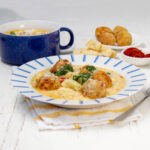 Savory and comforting slow cooker Tuscan meatballs with gnocchi on a plate.