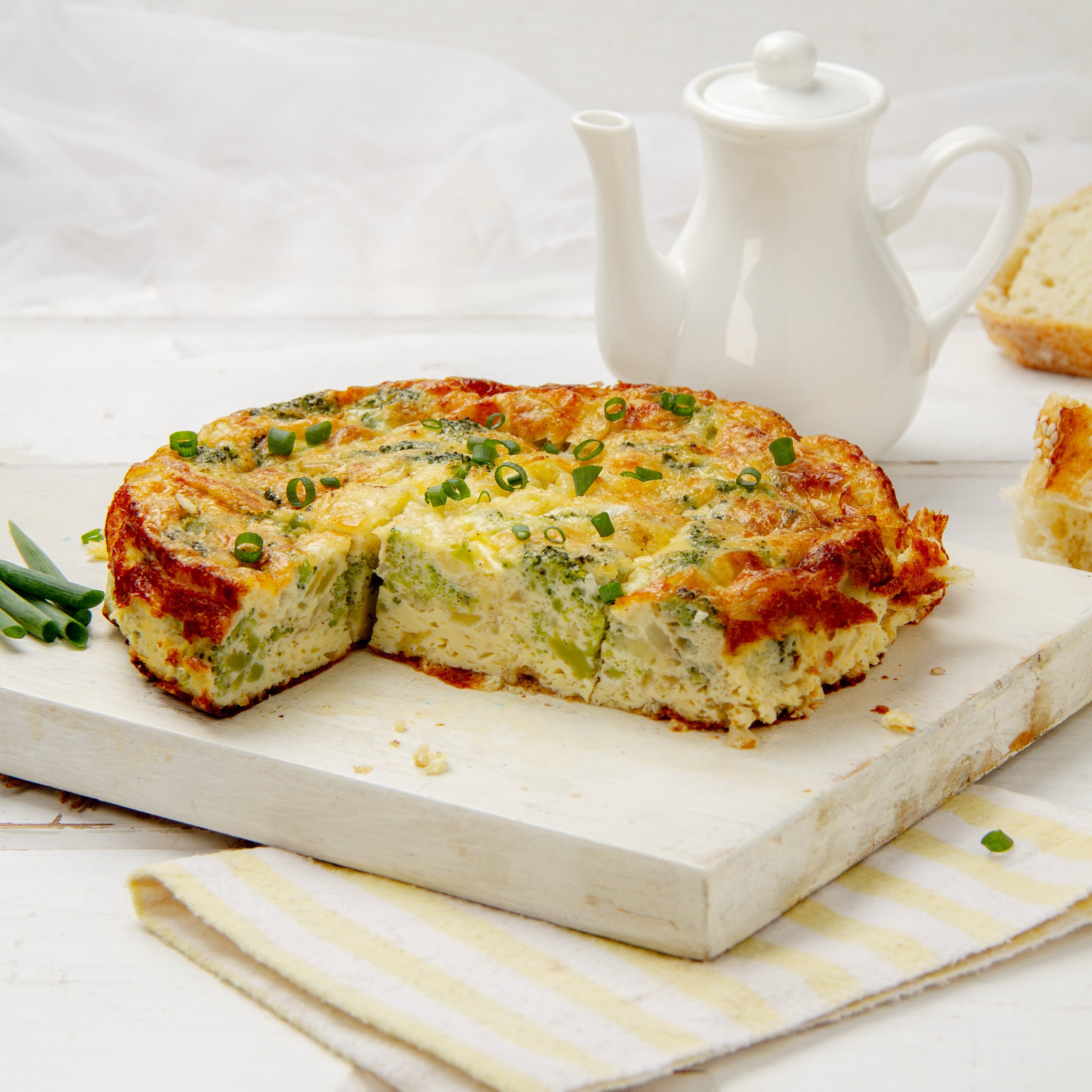 Hearty broccoli cheese breakfast egg bake on a cutting board.