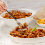 Meaty Brunswick stew in a dish with a fork.