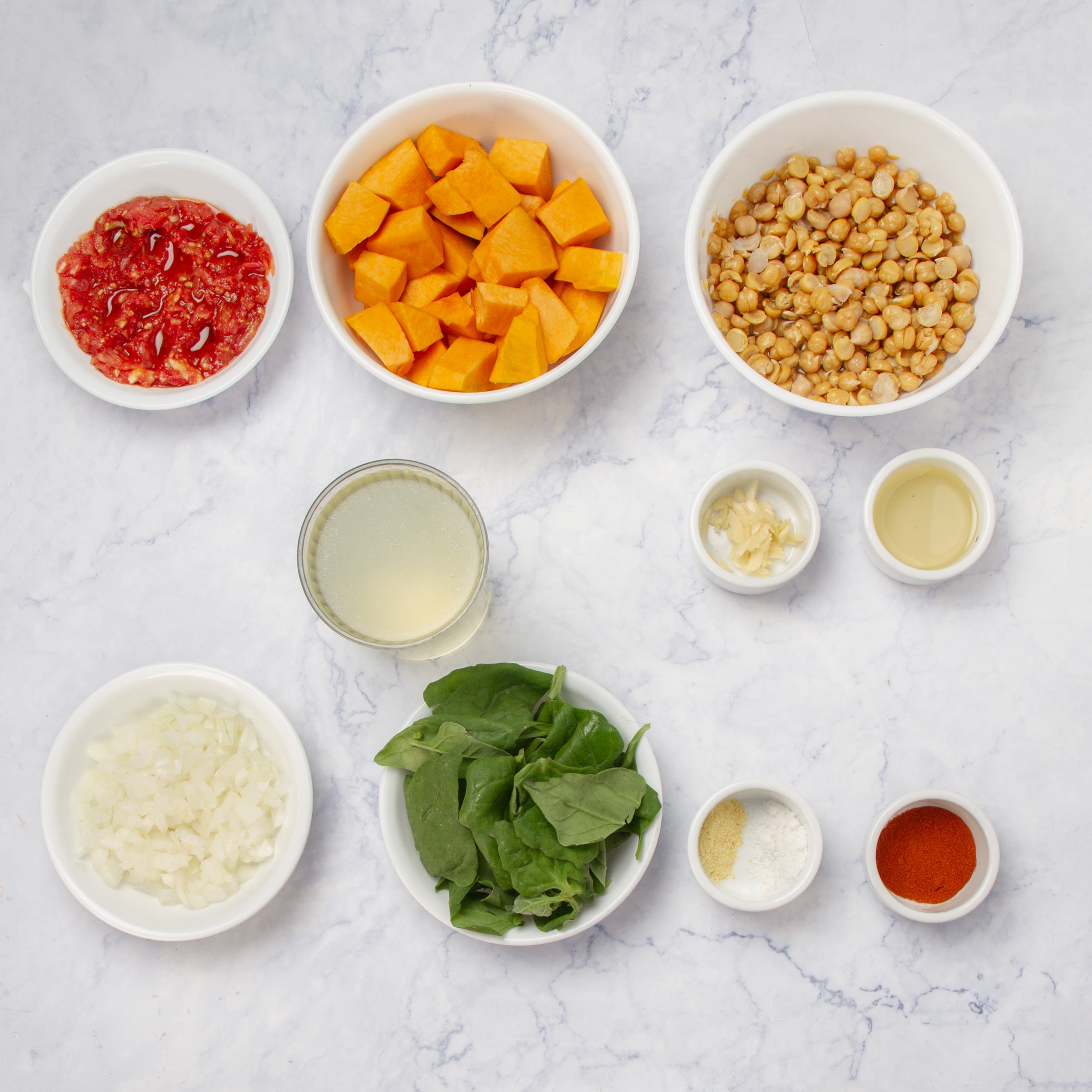 Chickpea stew ingredients in separate dishes on a counter top. 