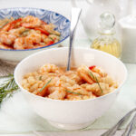 Creamy and satisfying Lemony shrimp and bean stew in a bowl with a spoon.