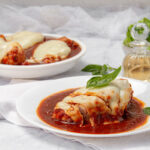 Cheesy Pizzaioli Chicken with sauce and fresh basil garnish on a plate.