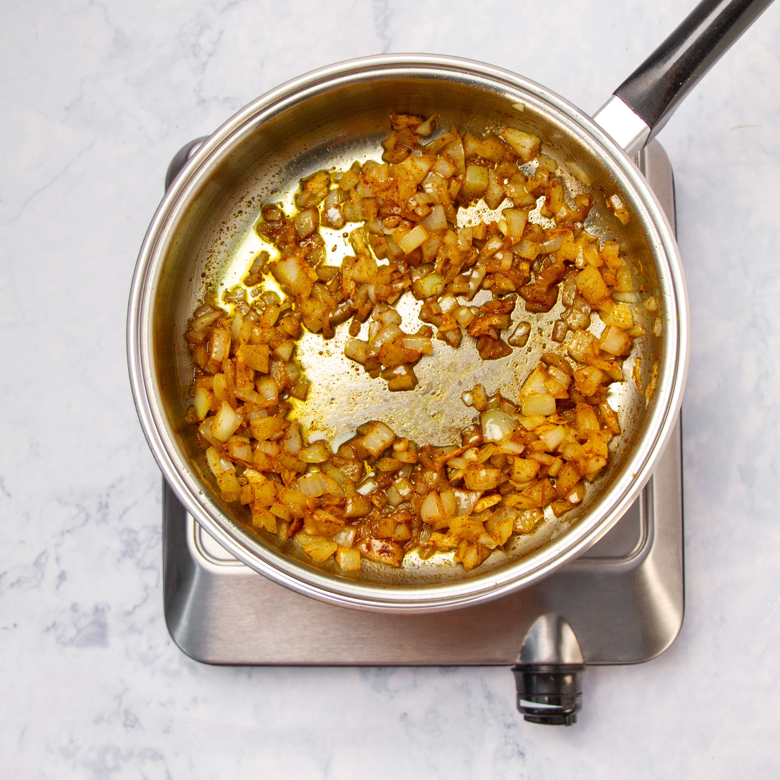 Aromatics saut&eacute;ing in a pan. 