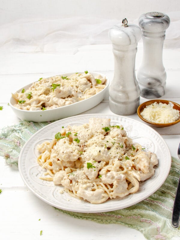 Creamy Angel Chicken Pasta on a plate with salt and pepper shakers on the side.