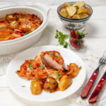 Spicy one pan piri-piri chicken on a plate with potatoes.