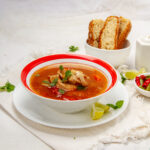 Warm and comforting Caldo Tlalpeño soup in a bowl with bread on the side.