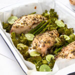 Herbaceous tarragon chicken with asparagus in a serving dish.