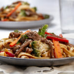 Vibrant flavor-packed Beef Noodles with veggies and tender beef on a plate.