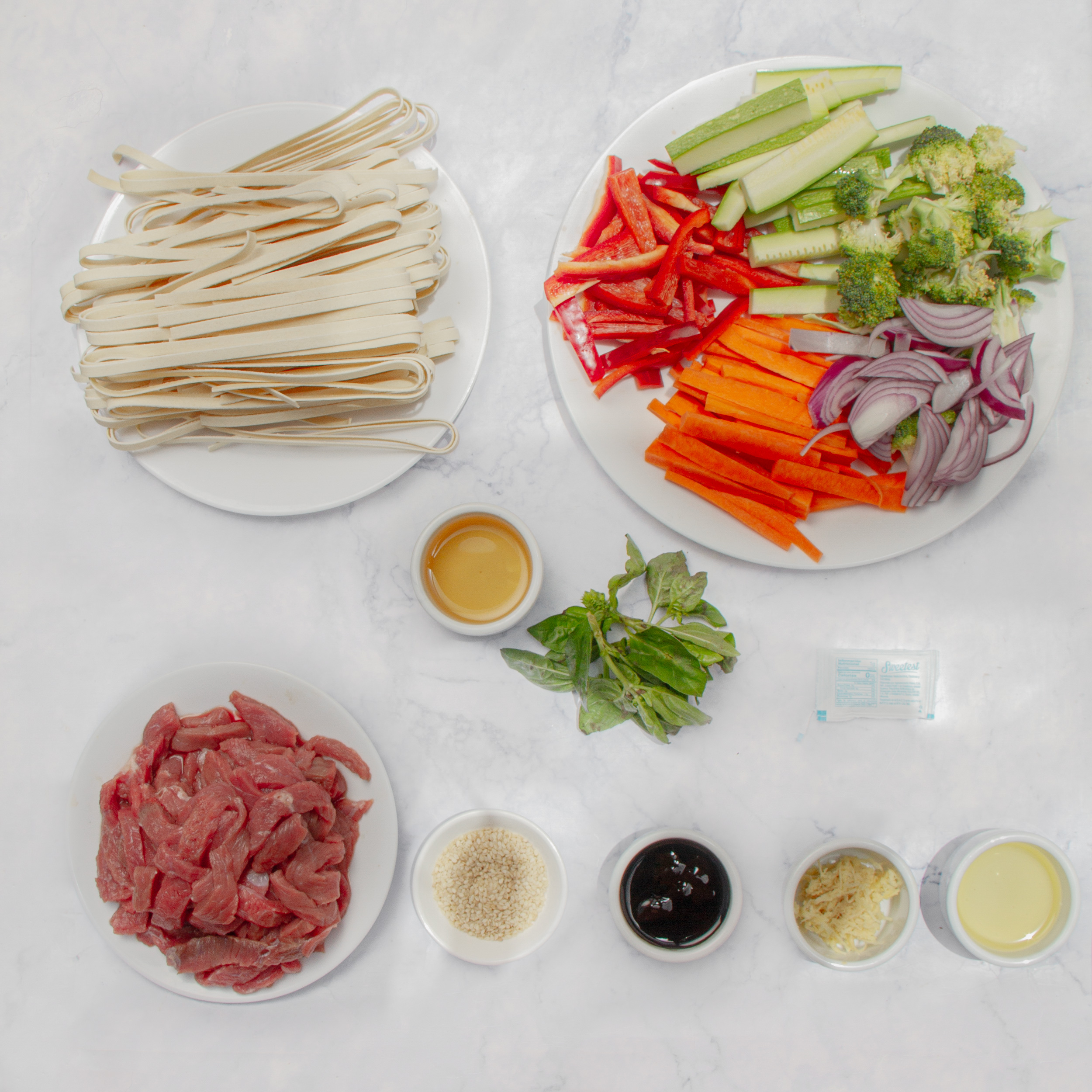 Ingredients for Chinese-style Beef Noodles in separate dishes on a counter.