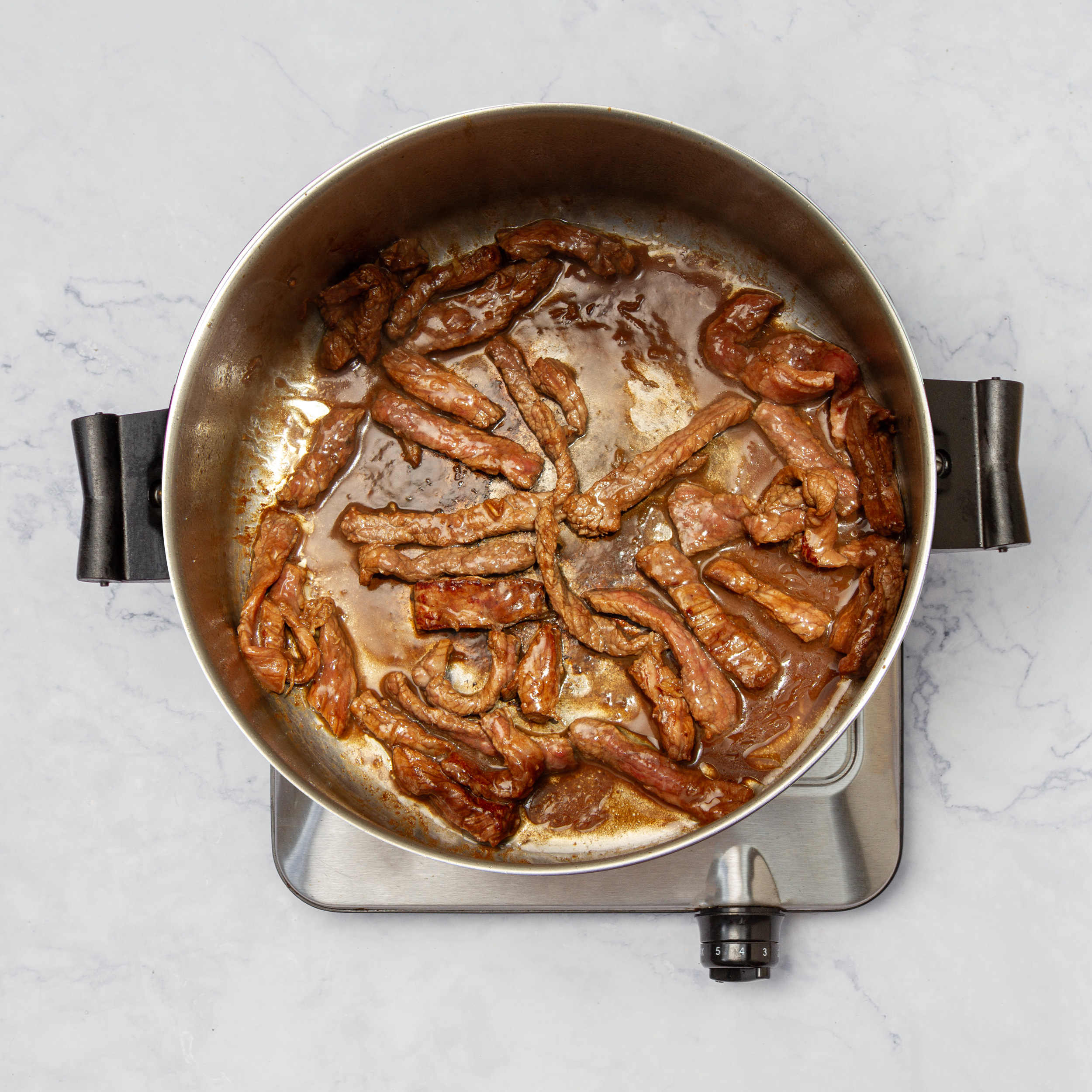Beef stir-frying in a hot pan.