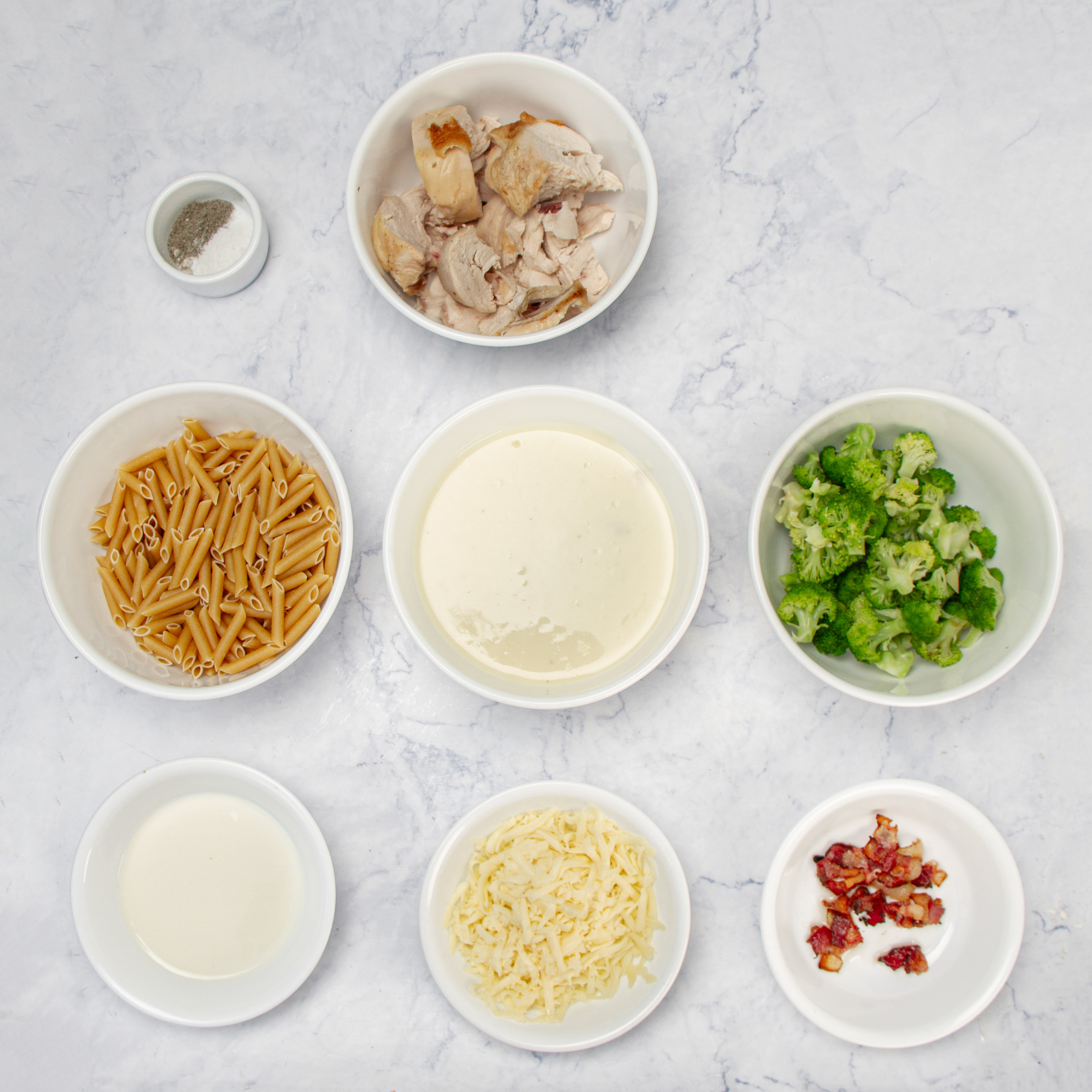 Chicken Bacon Alfredo Pasta Bake ingredients in separate dishes.