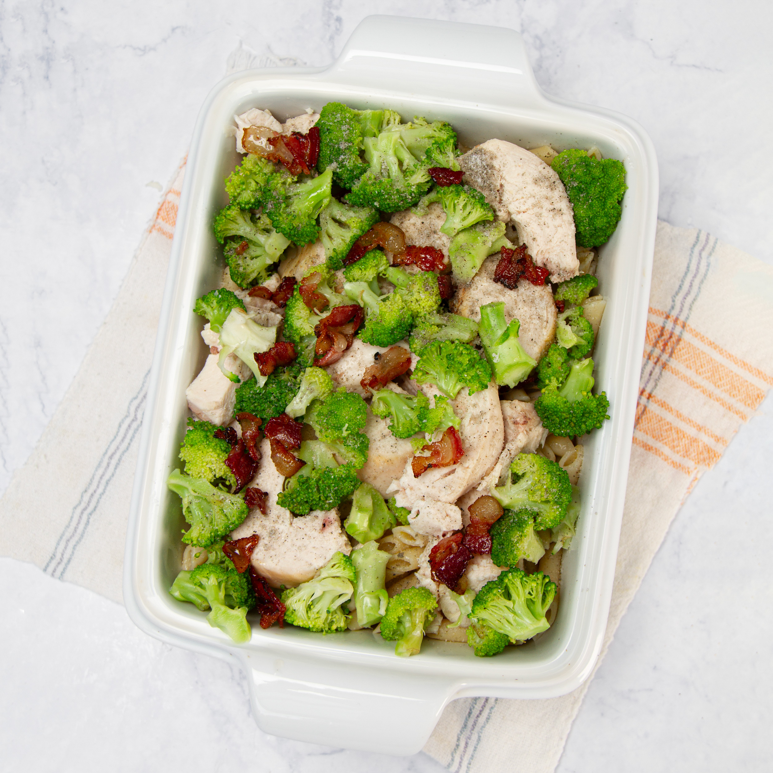 Cooked chicken, broccoli, and bacon added on top of the pasta.