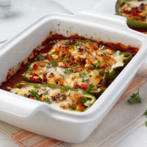 Spicy, loaded, and delicious Enchilada Stuffed Poblano Peppers, topped with melty cheese and fresh herbs.