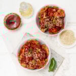 Crispy and bold Firecracker Chicken bites in a bowl with a jalapeño on the side.