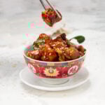 Healthy general Tso's chicken in a bowl with sesame seed garnish.