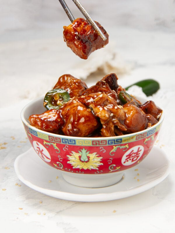 Healthy general Tso's chicken in a bowl with sesame seed garnish.