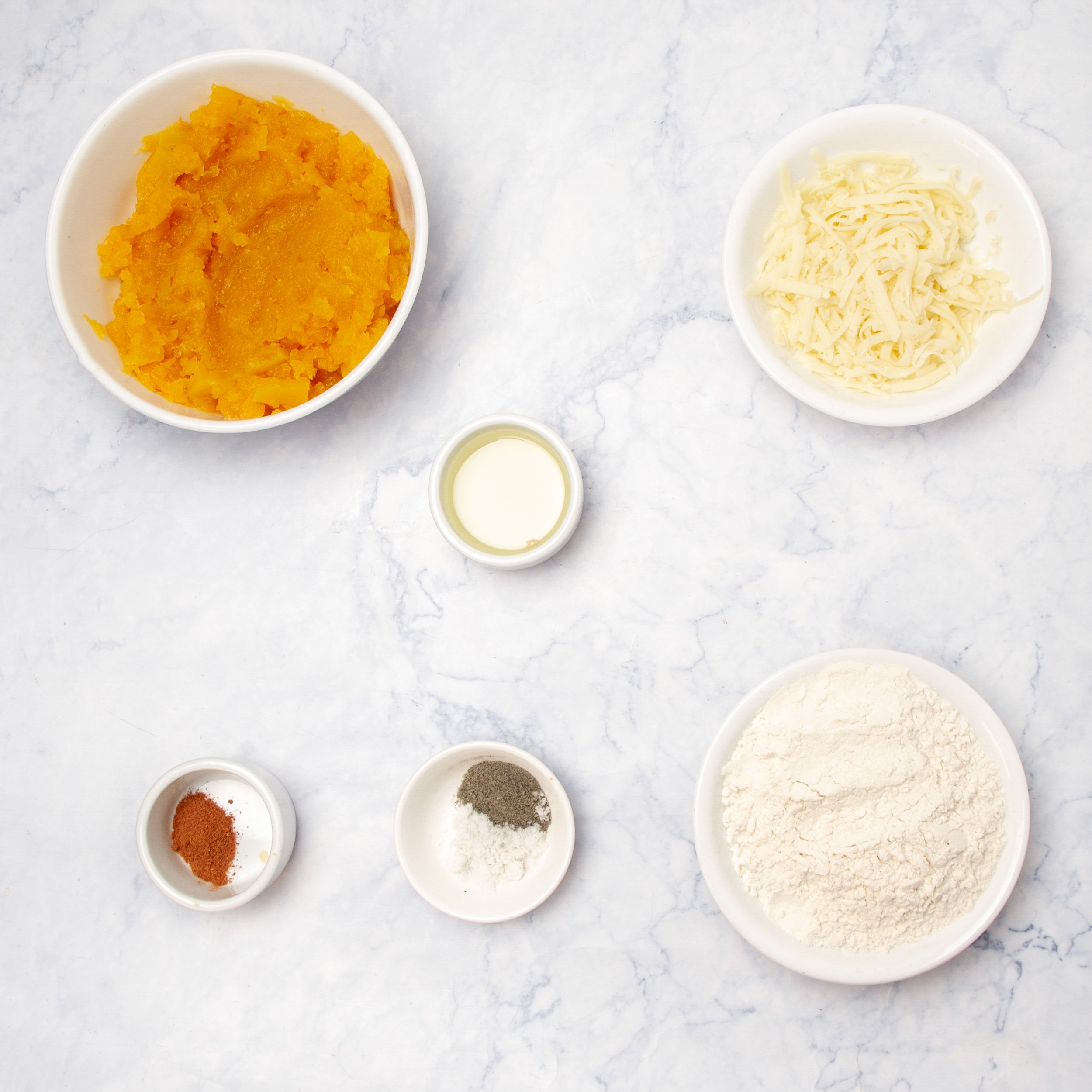 Simple and accessible ingredients for pumpkin gnocchi in separate dishes.