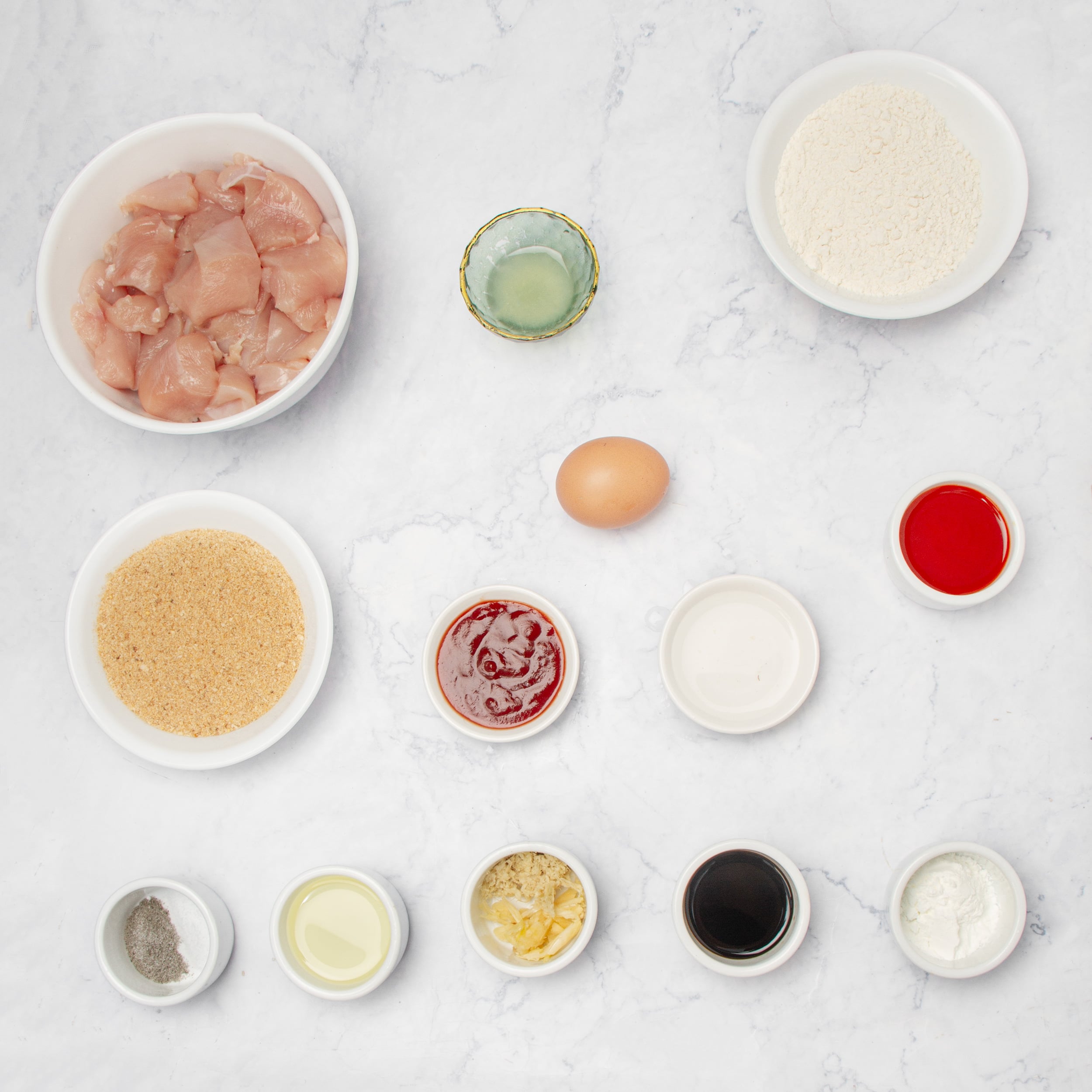 Firecracker Chicken ingredients in separate bowls on a countertop. 