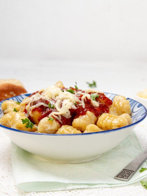 Soft and flavorful pumpkin gnocchi with sauce and cheese in a bowl.