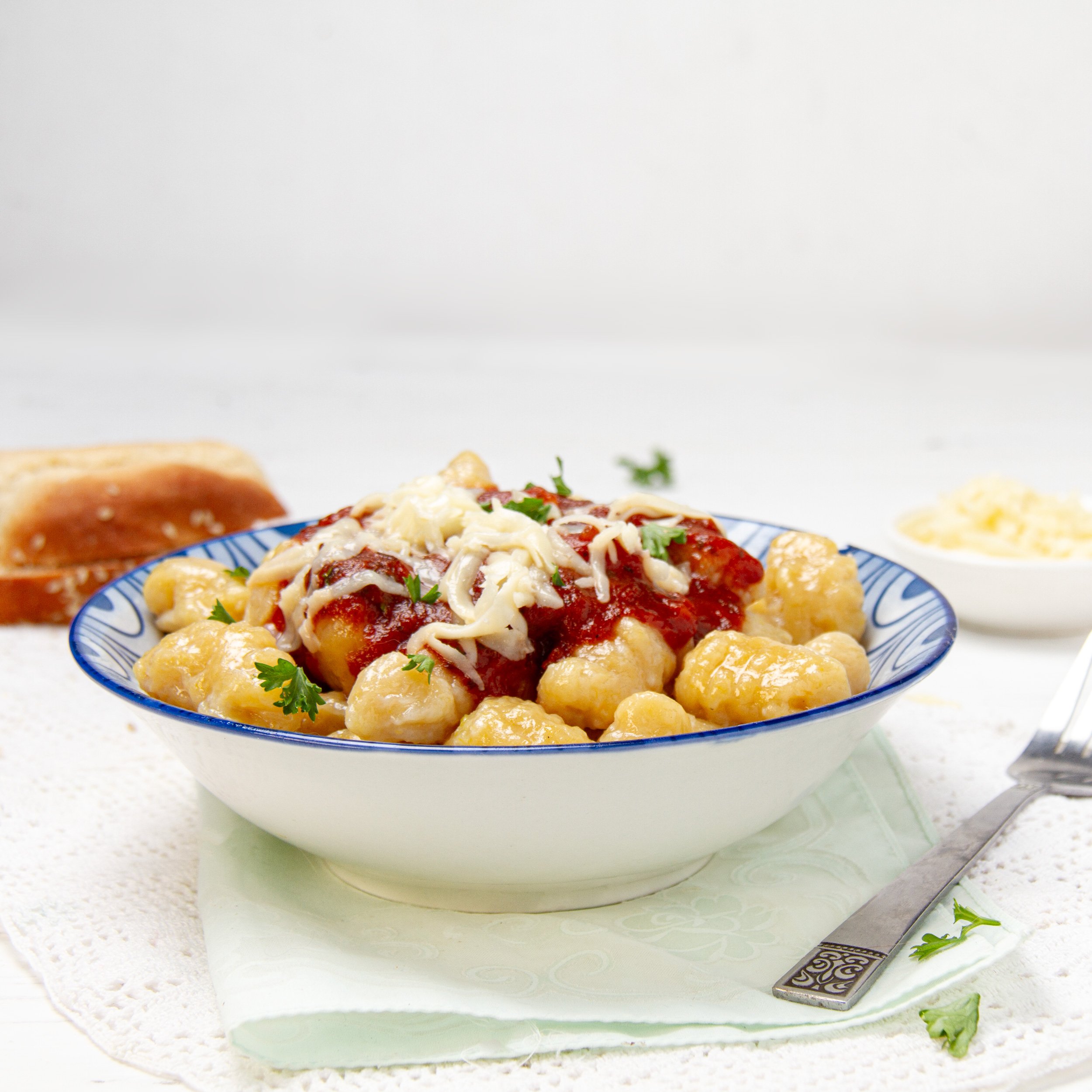 Soft and flavorful pumpkin gnocchi with sauce and cheese in a bowl.
