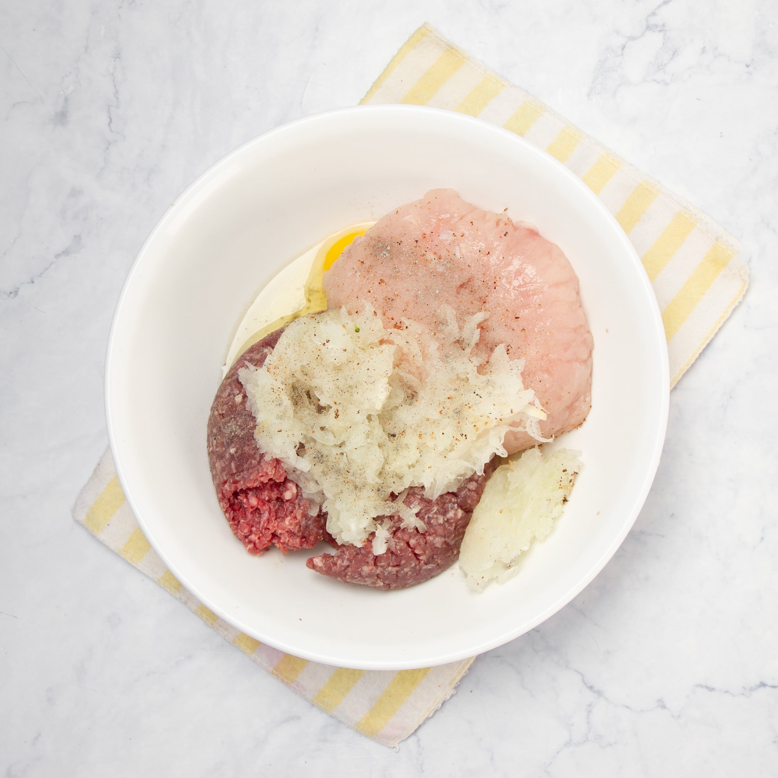 Raw meat and seasonings combined in a small bowl. 