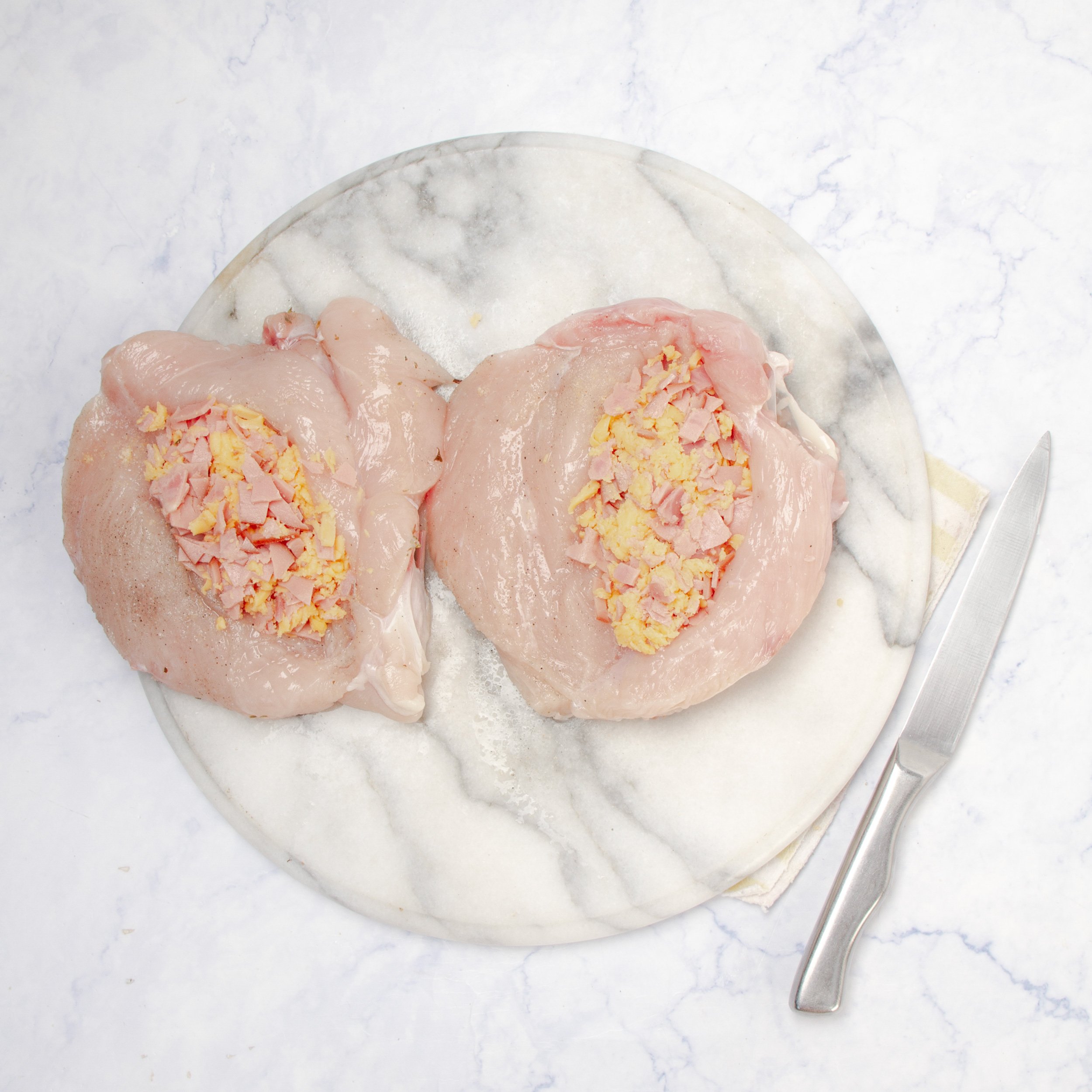 Raw chicken breasts slit open and stuffed with the garlicky meat and herb filling.