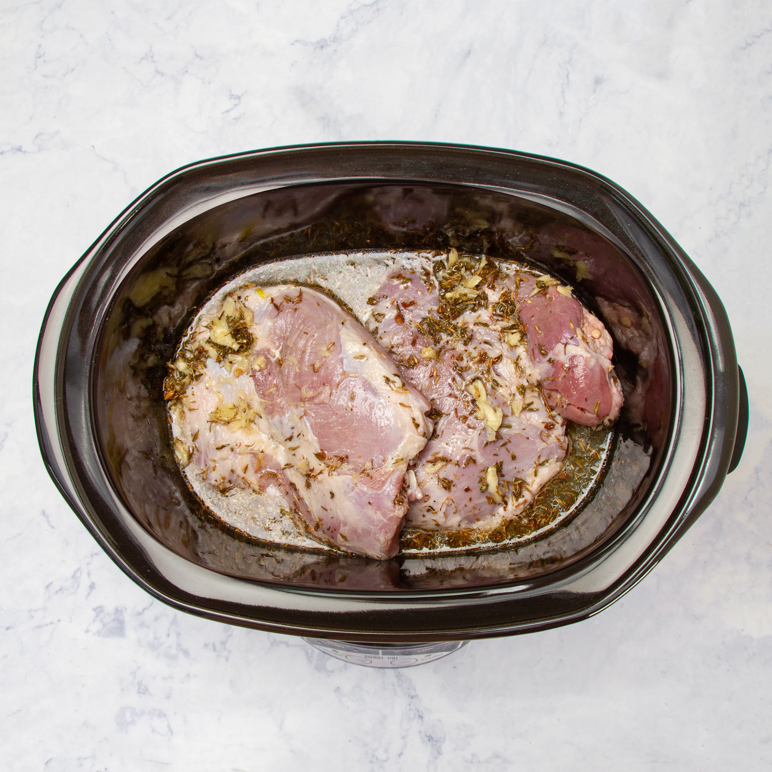 Pork and marinade in the cooker basin. 
