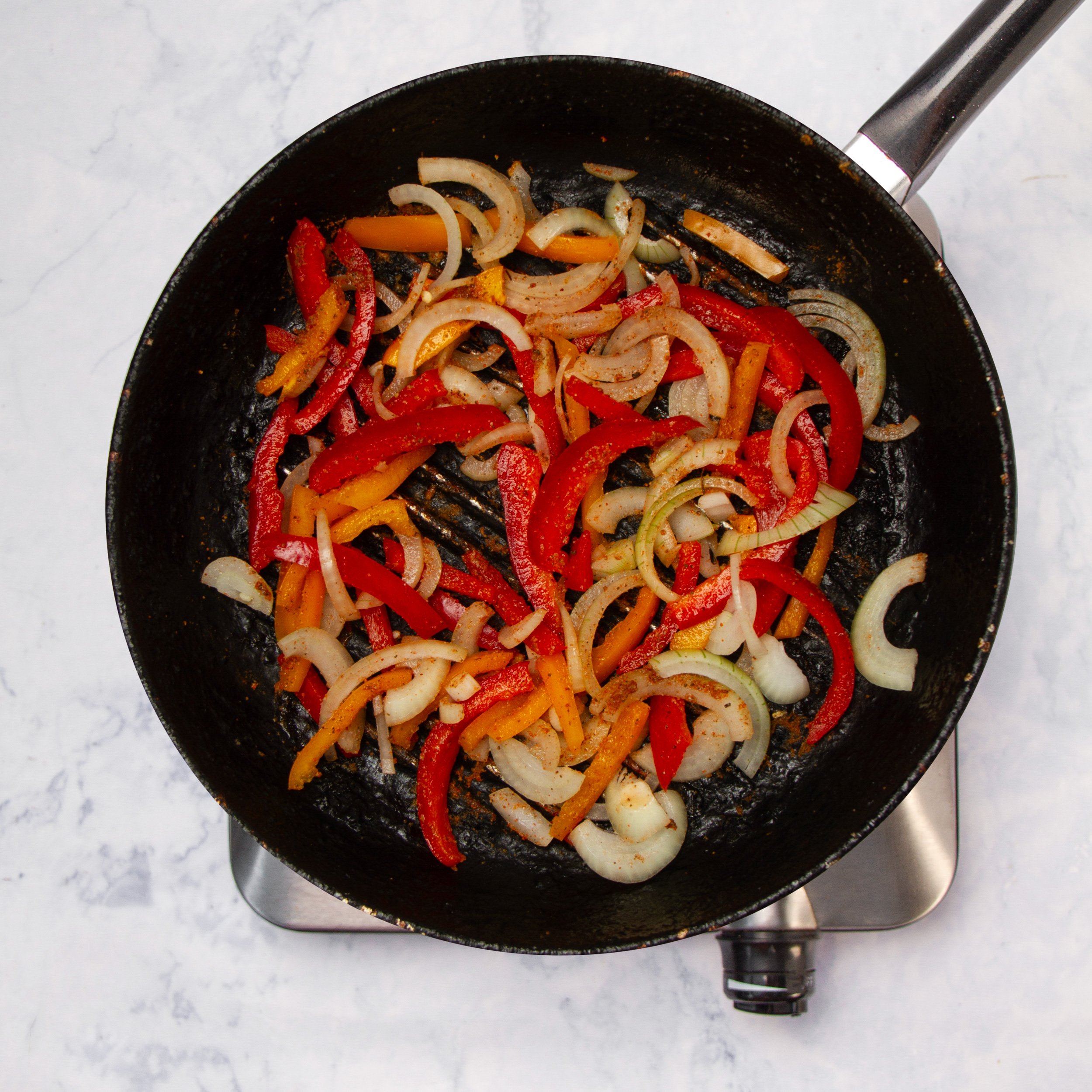 Sliced vegetables pan-frying in the skillet. 