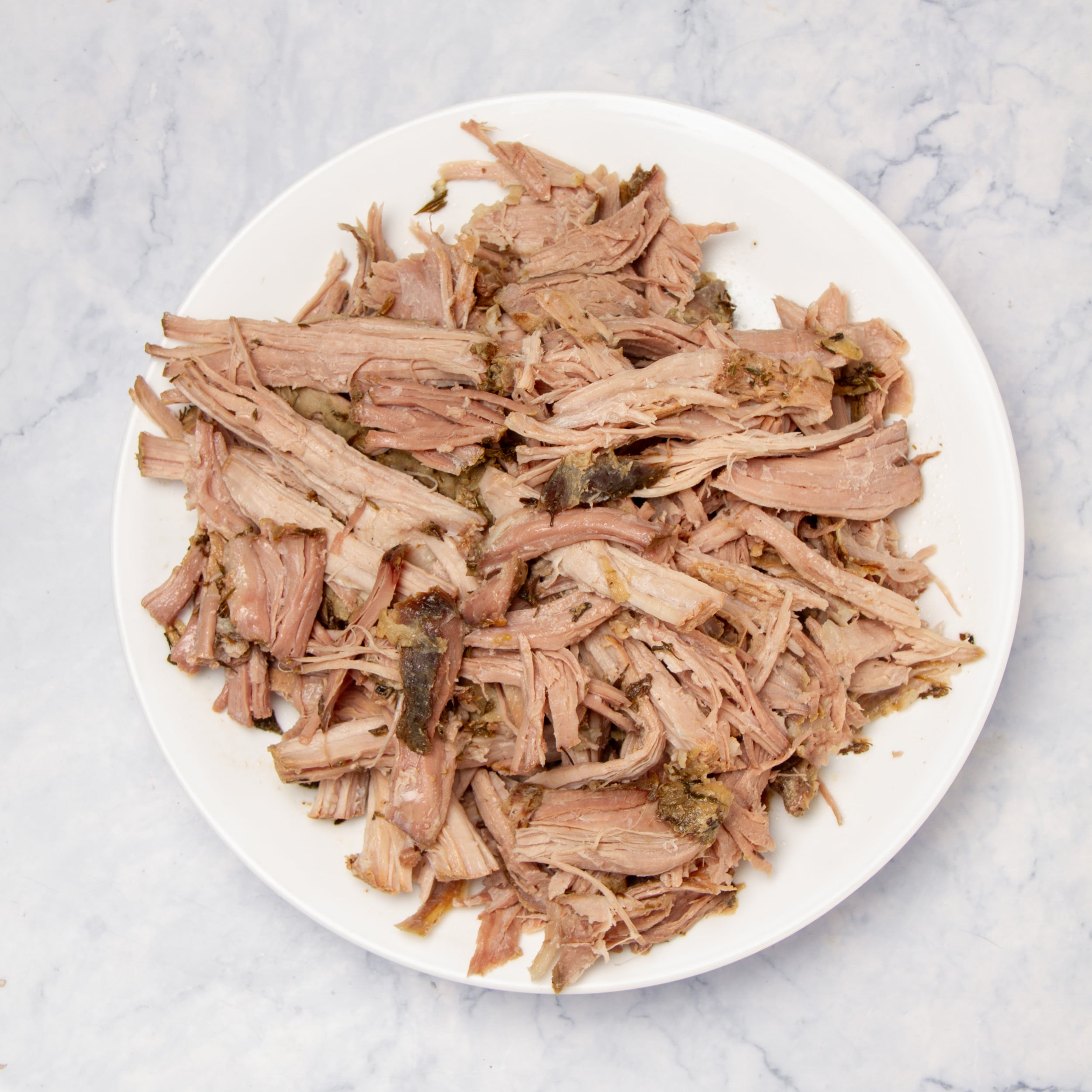Juicy and tender shredded pork on a plate. 