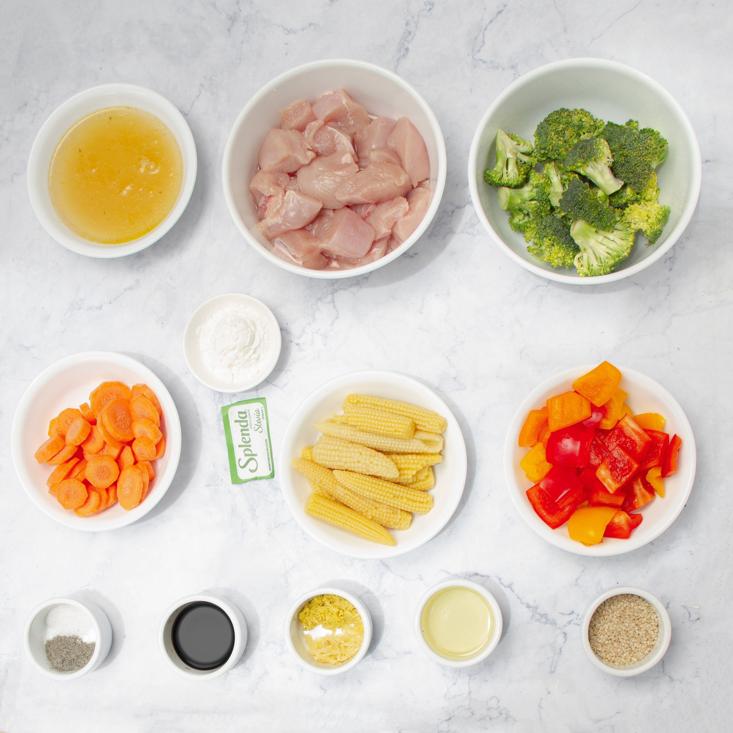 Healthy chicken stir fry ingredients in separate dishes. 