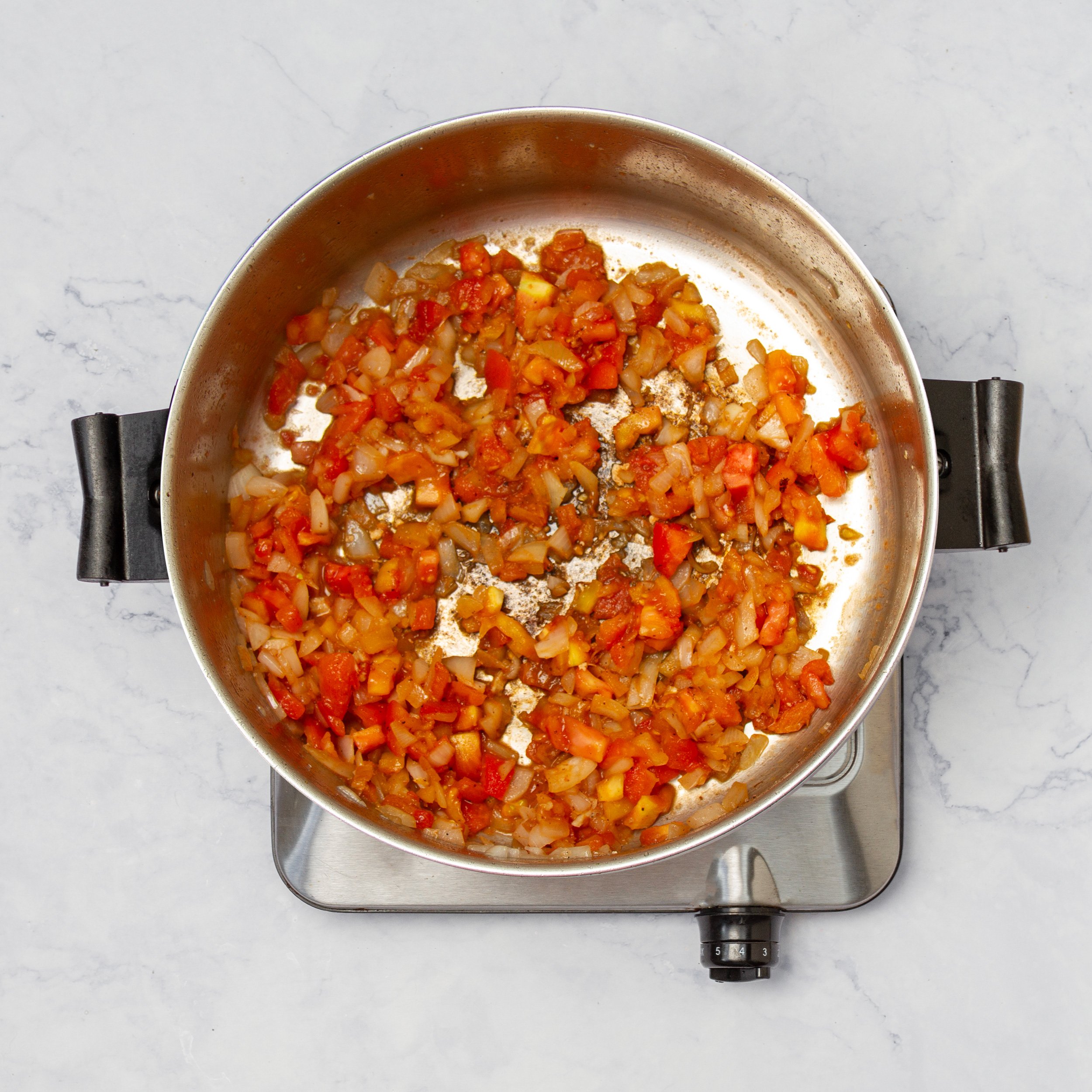 Aromatic vegetables cooking in the pan, with the chicken removed.