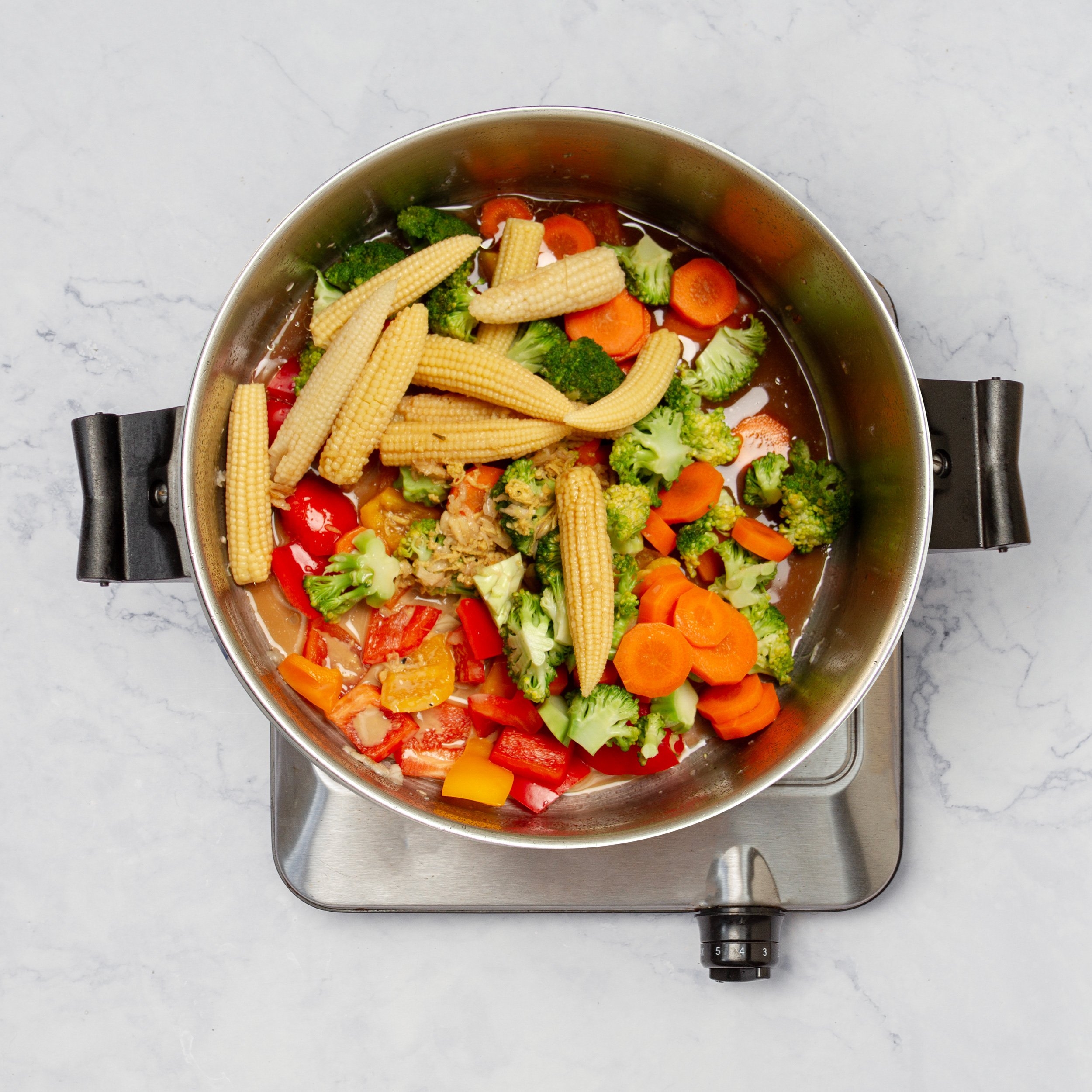 Fresh veggies combined with sauce and chicken in the stir fry pan. 