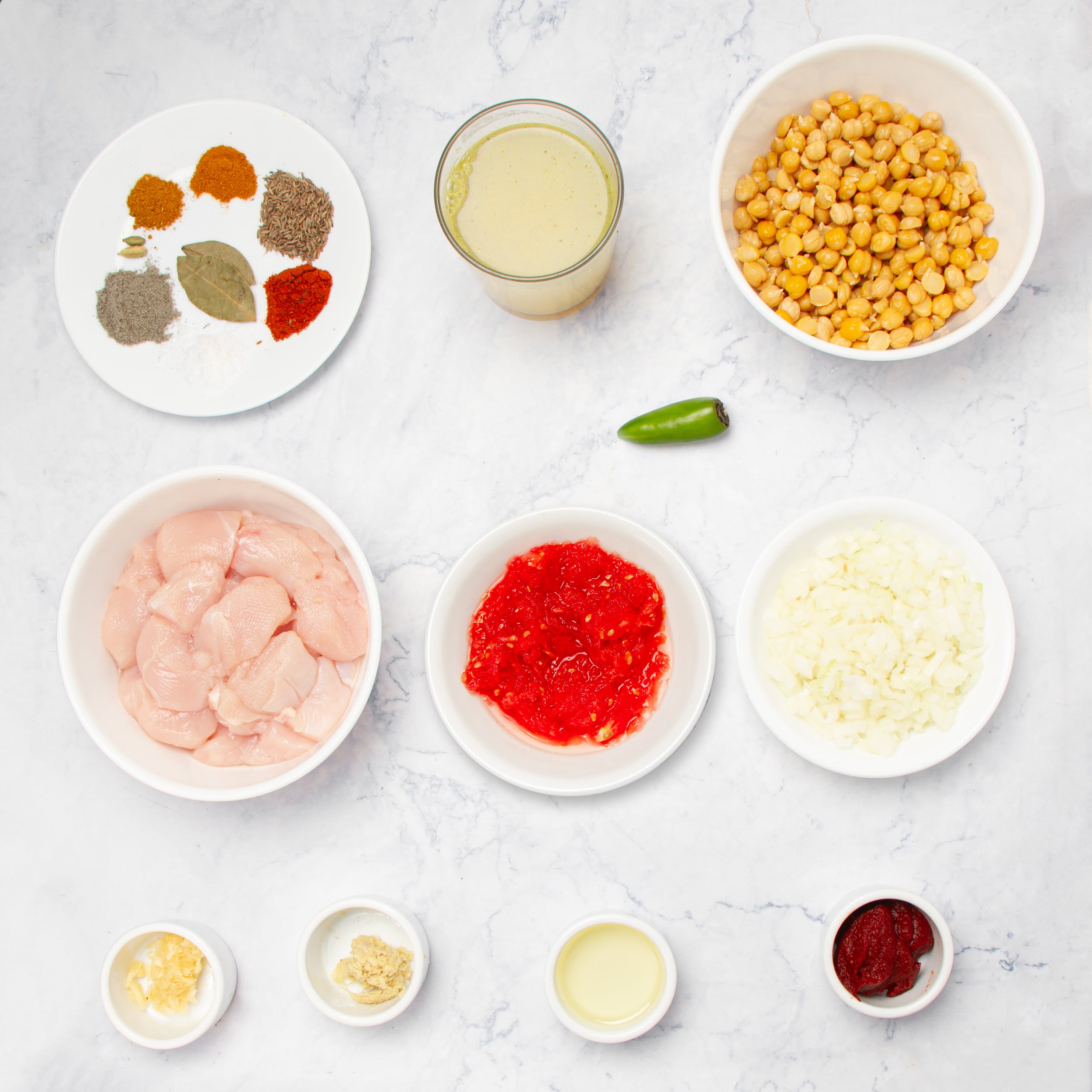 Ingredients for Chicken and Chickpea Curry in separate dishes. 